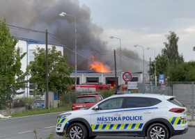 Požár v průmyslové hale v Uhříněvsi. Hasiči ho na jednom místě nechávají kontrolovaně vyhořet